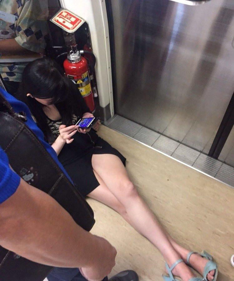 现在奇葩真多啊,这么好的妹子,没事坐在地铁门口玩手机