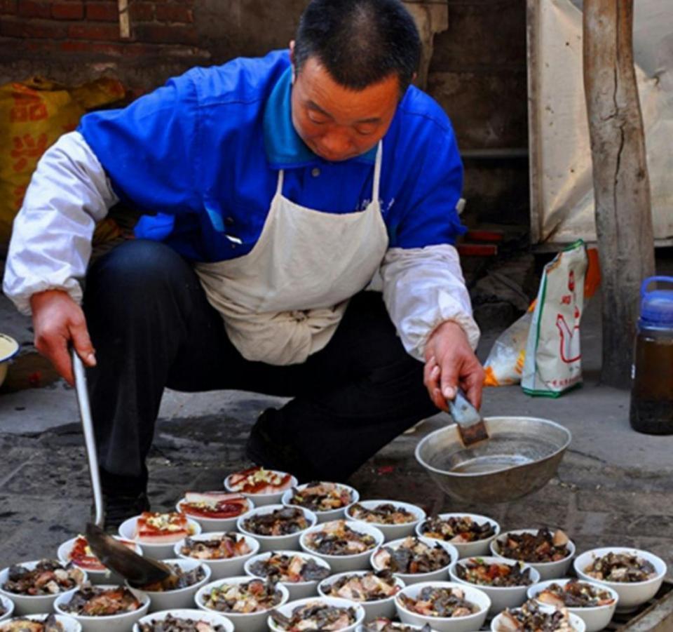 这是河北农村婚宴后厨现场:师傅正在给上屉之前的蒸碗浇一种卤汁.