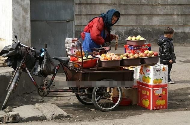 图为在铁轨边摆摊卖东西的妇女.