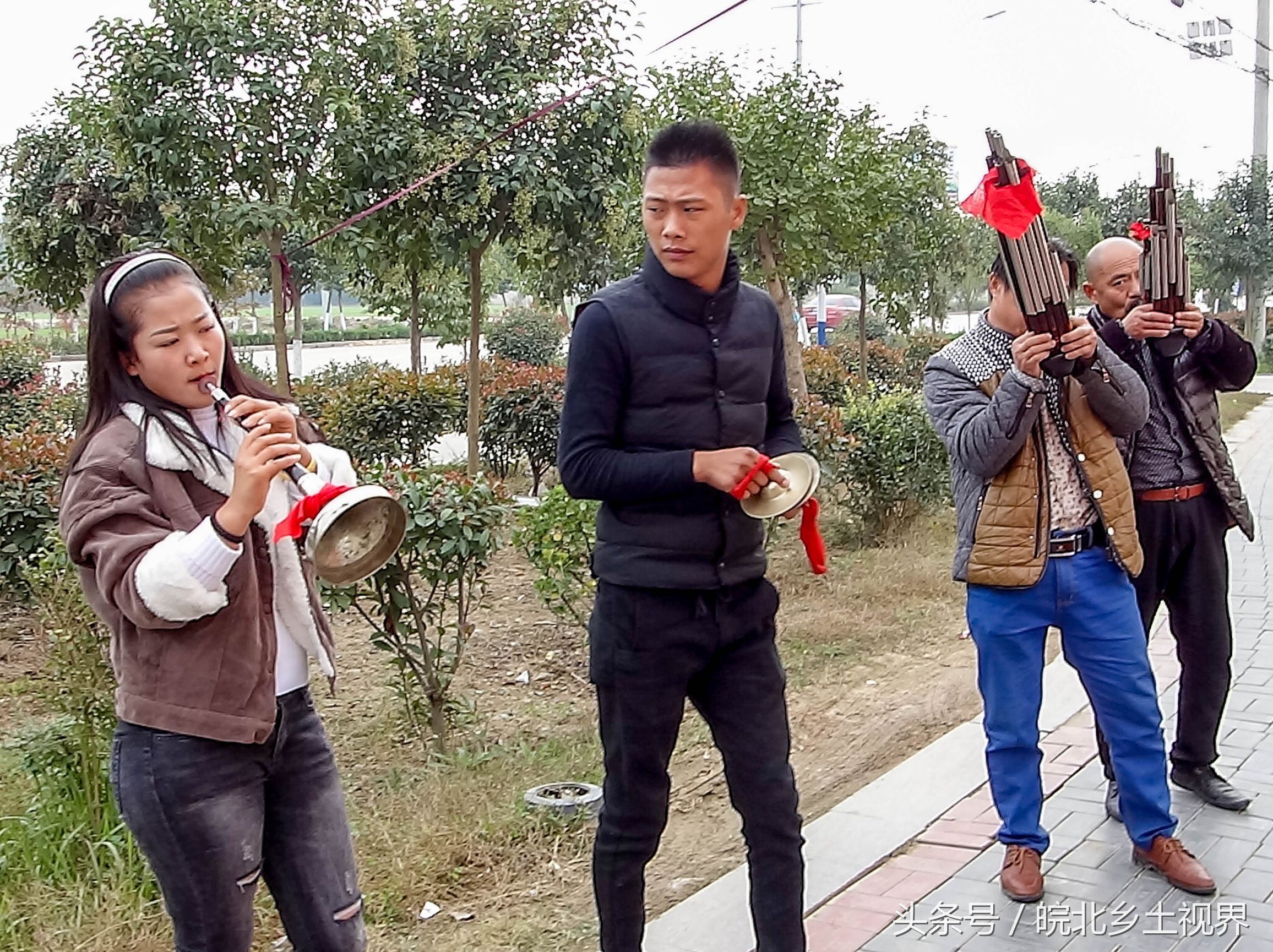 农村的喇叭班子敲着铜锣,吹着乐器,为新人的低碳婚礼奏乐.