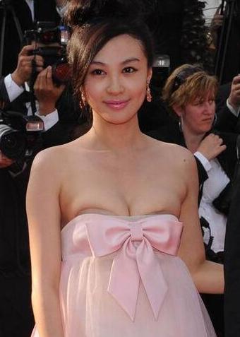 图为:李菲儿参加第63届戛纳红毯走秀,一身粉色洋装出镜的她不慎抹胸