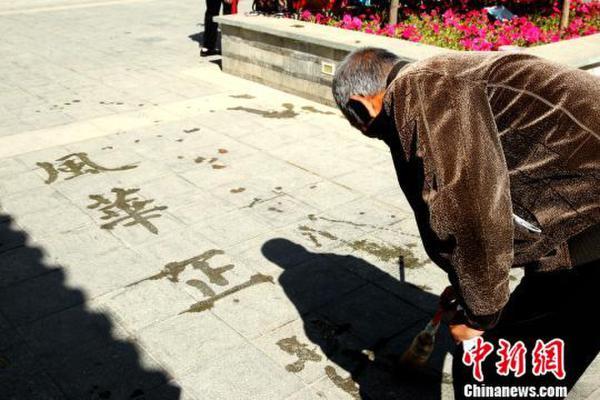 图为西宁晨练老人用自制的"毛笔"在公园空地上写书法.张添福 摄