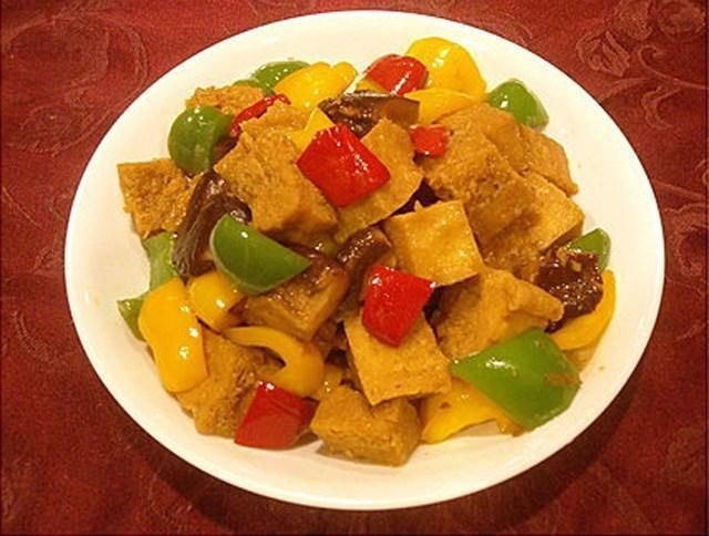 青椒.红椒及炸过的冻豆腐,并加入素蚝油及水2/3杯煮至汤汁快收干.