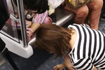 地铁上孩子把奶茶洒在地上 妈妈拿纸巾擦干净
