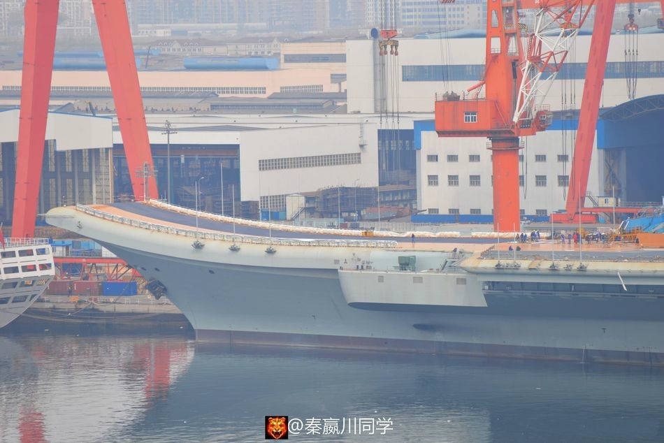 从日前社交网站公开的新照来看，国产航母飞行甲板的摊铺工程进展还是蛮快的，几天不见就由底漆的橙色变成了大部分的黑色；当整个摊铺工程结束后，就会重刷一遍飞行标识了，说不定连舷号一块给刷了，非常令人期待，不知道是否能赶得上4.23海军节的庆祝活动。