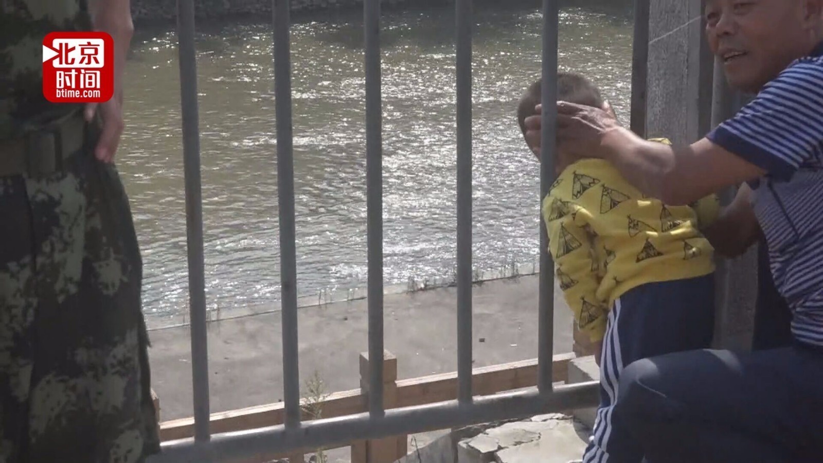 惊险!2岁幼童路边玩耍头被卡护栏 爷爷哭笑不得