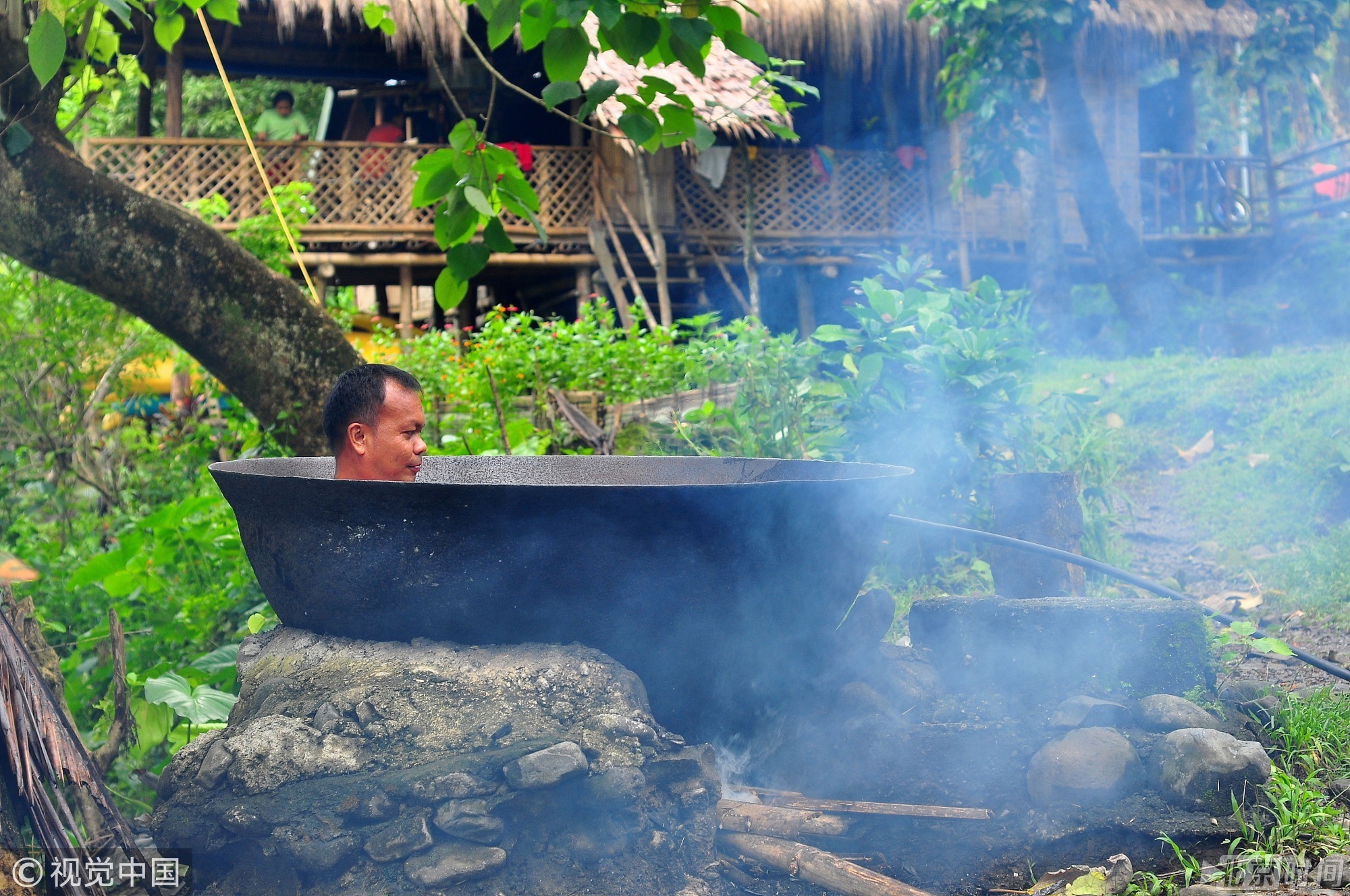 人躺在一口大锅中，下面点着柴火加热，体验一种独一无二被煮的感觉。