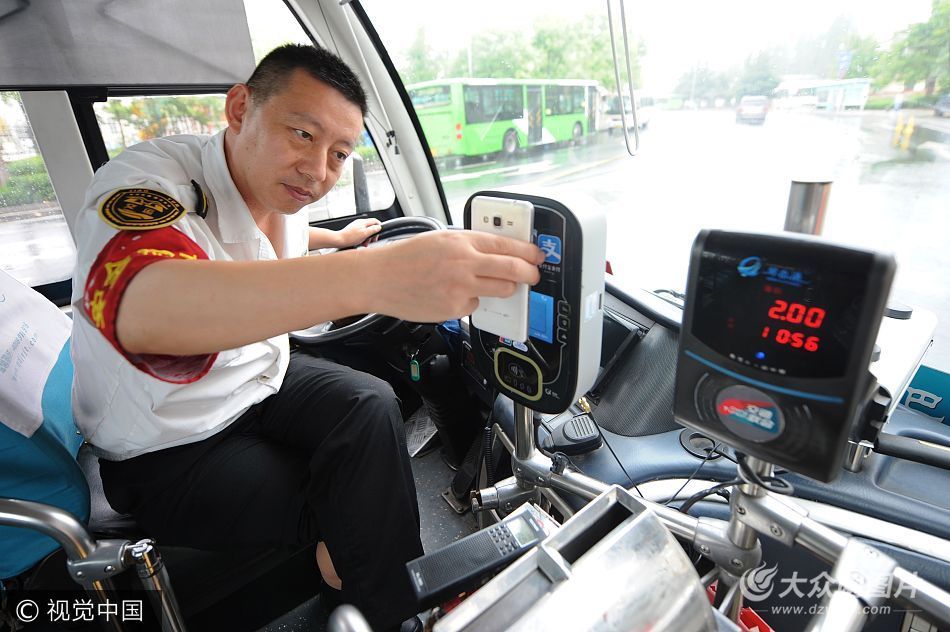 巴士31路公交车安装试运营"移动支付",图为驾驶员协助乘客扫描付费