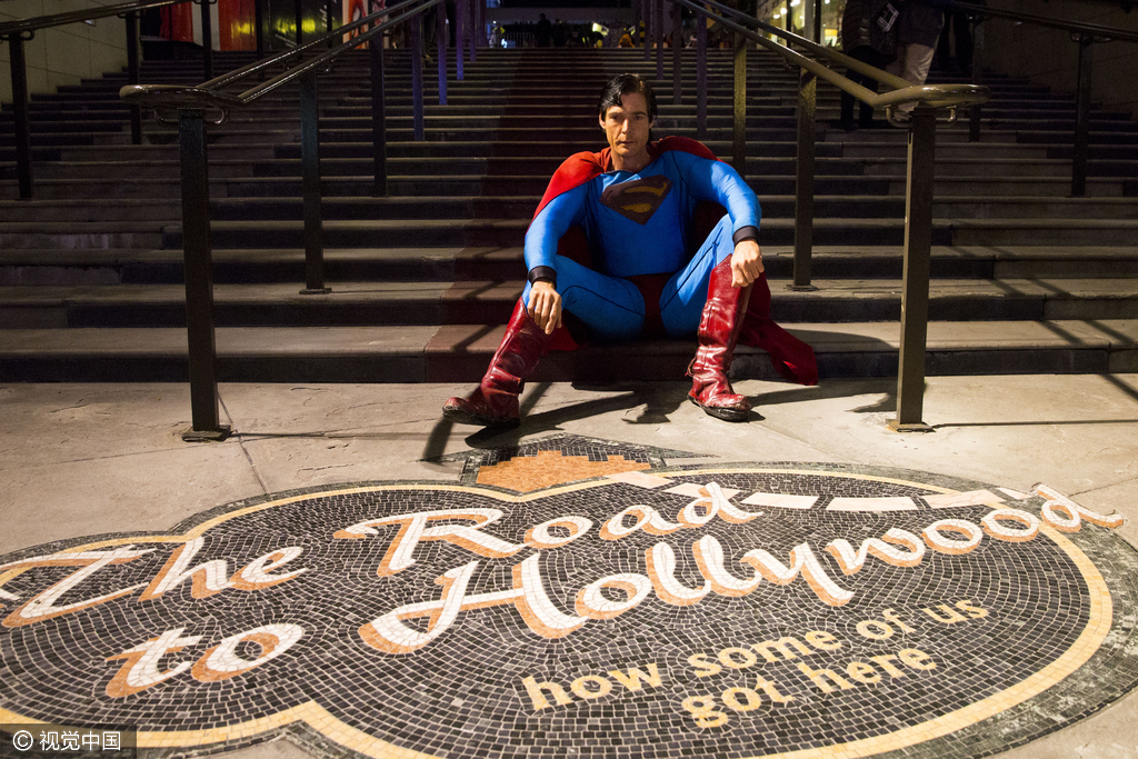 当地时间2016年1月9日，美国洛杉矶，克里斯托弗·丹尼斯身披超人制服坐在好莱坞大道。