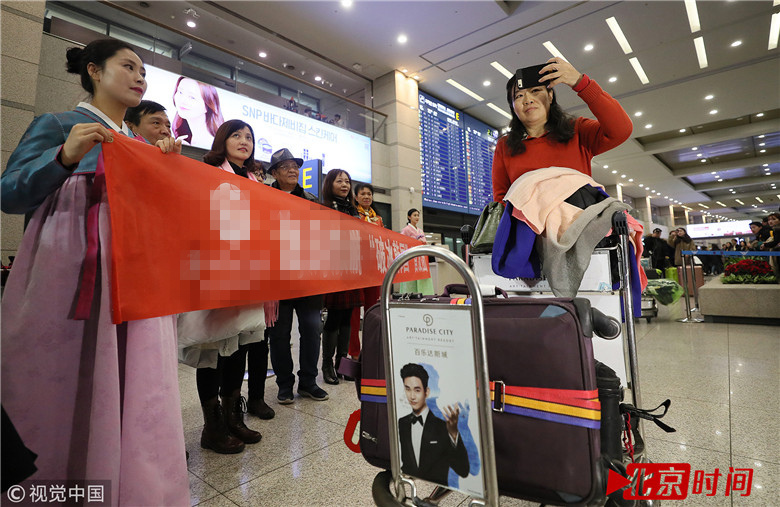 负责此次接待的韩国旅行社职员身穿传统服装，笑容满面，为中国游客献上鲜花。中国游客则拉开写有“破冰韩国首发团”的红色条幅，在接机大厅中开心地拍摄纪念照。（三韩观察家）