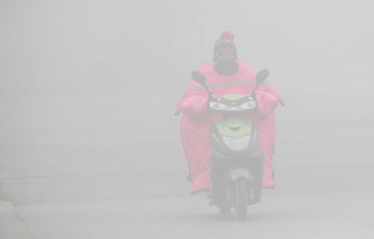 11月26日，全国多地出现大雾天气，影响市民出行。中央气象台26日晨通报，全国多地出现低能见度的大雾天气，江苏中南部、浙江北部、安徽南部等地能见度不足500米，局地能见度不足50米。图为安徽省淮北市民戴口罩在大雾中骑车出行。