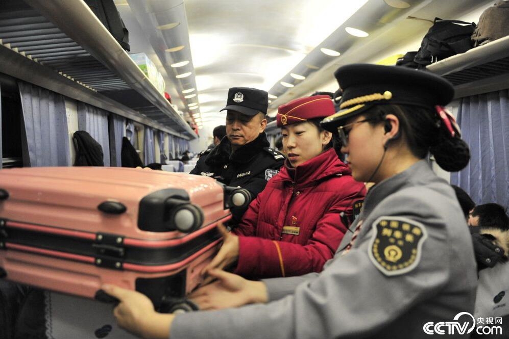 90次列车上,列车安全员高燕敏与乘警长王荣峰对旅客行李进行安全检 