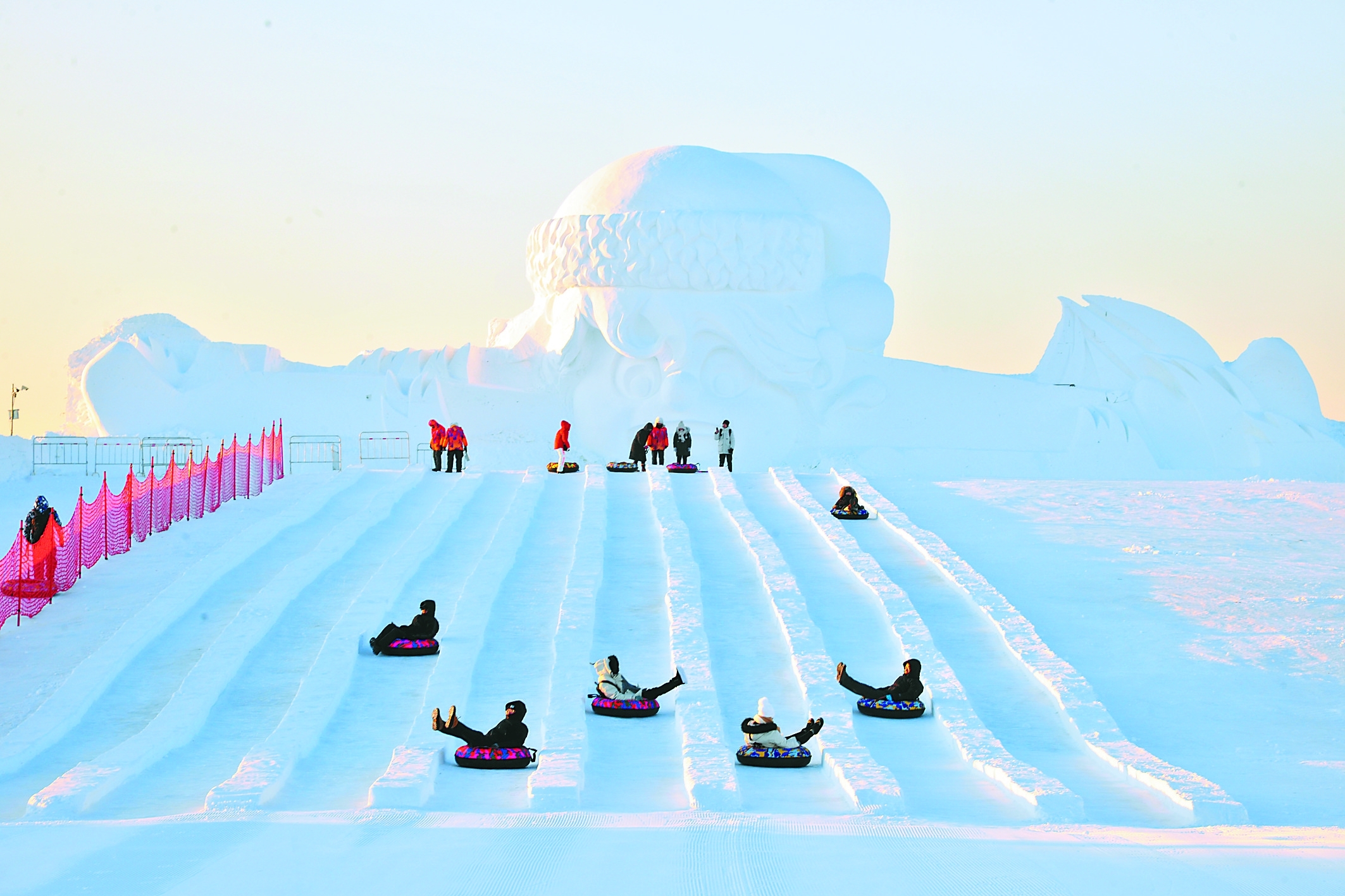 中小学生在哈尔滨市群力赏冰乐雪园内玩雪地足球.