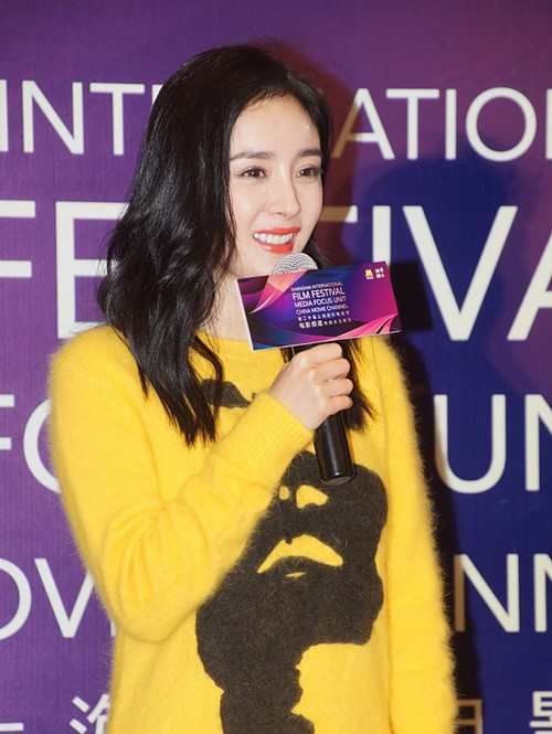 杨幂身着黄色上衣搭配黑色短裙,台上90度鞠躬