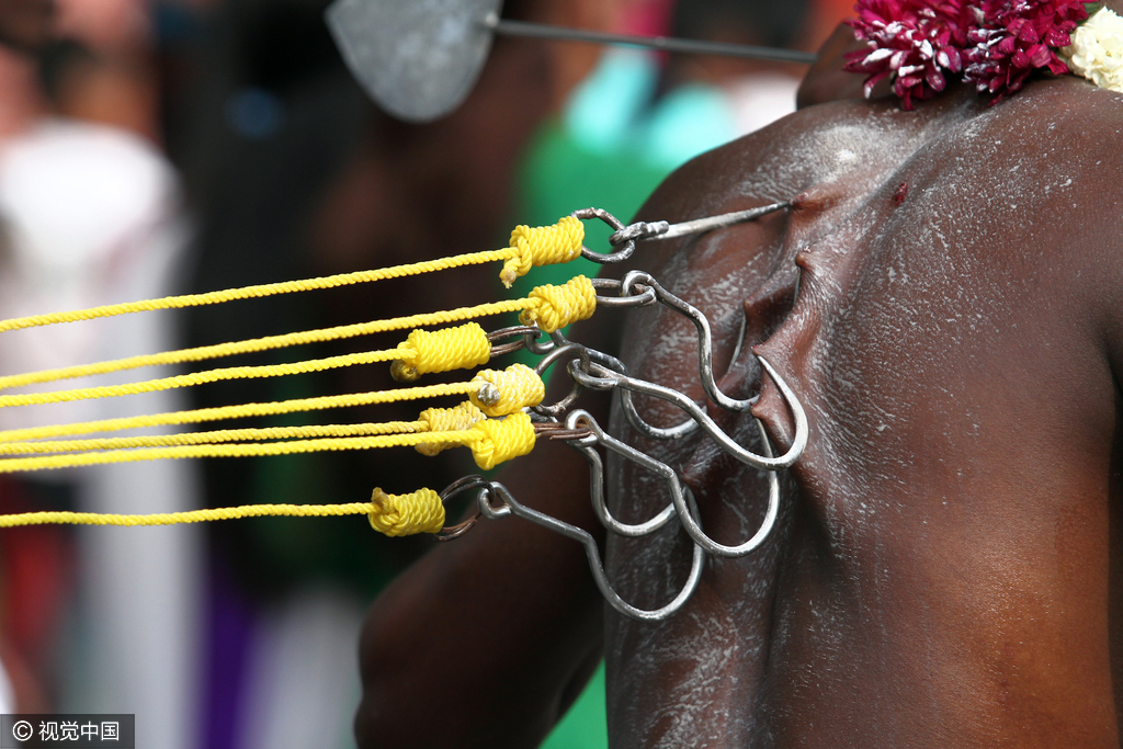 当地时间7月24日，印尼棉兰，印度教信徒庆祝“大宝森节”。信徒的祭祀仪式有很多种，例如：剃头，做法事，用银针刺穿舌头、双颊等，或是背着巨大的钢制弓形枷锁(负卡瓦第)。大宝森节活动持续24小时，从一座印度神庙游行到另一座印度神庙，进行祷告和献祭，并且借此表示对神明忠贞不移的信仰，祈求神明的赐福。