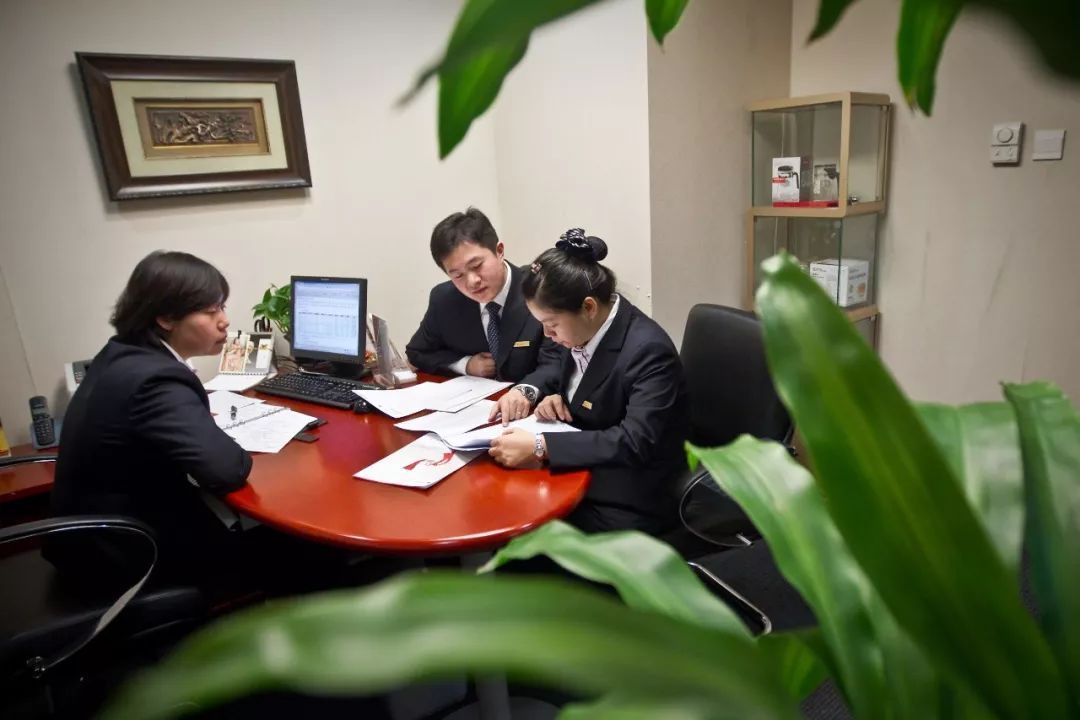 10月16日,80后金融理财师张然(中)和另外两位理财师同事进行业务交流