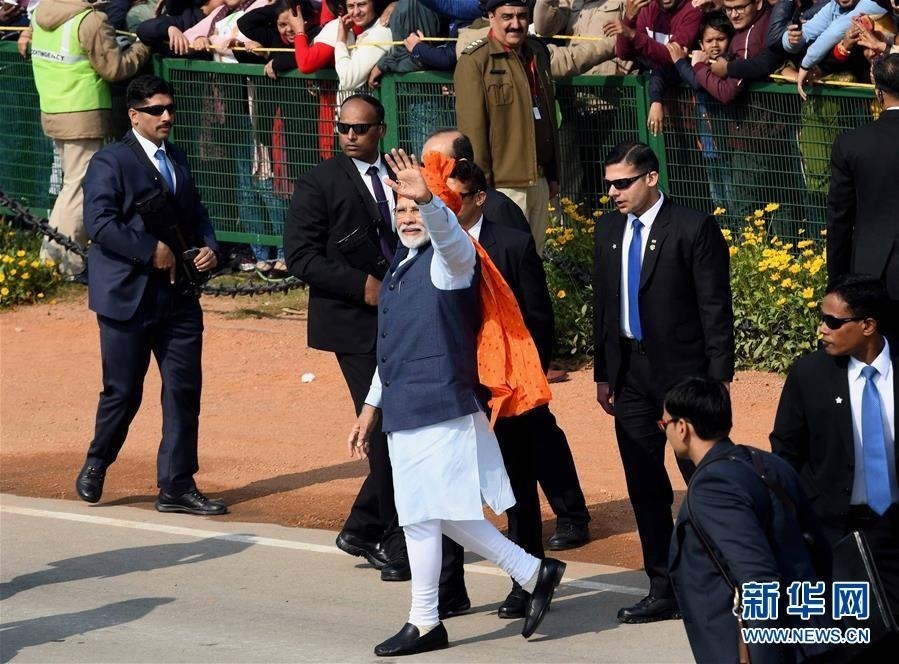 1月26日，在印度新德里，印度总理莫迪（中）在共和国日阅兵式后向人们挥手。 当日，印度首都新德里举行阅兵式，庆祝共和国日。 新华社发（帕塔·萨卡尔摄）