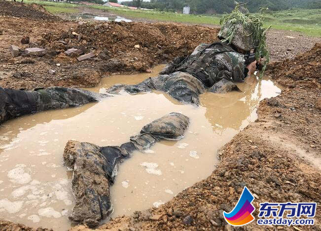 圖為戰士匍匐在掩體內,泥水已經淹沒了他的大腿 東方網記者曾炟 攝