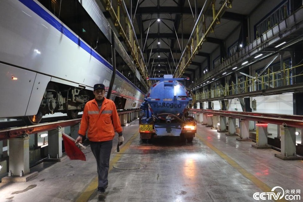 图为福州东车辆段职工邹克扬正在引导吸污车进入动车所.