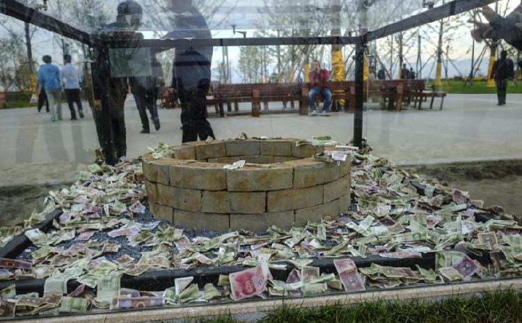 中国青年网消息，2017年10月12日，西安市刚开放的昆明池·七夕公园里，一个汉代陶井砖的玻璃展示柜里也被游客扔满了钱，其中甚至还有百元大钞。