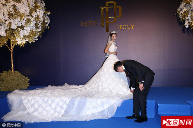 何润东贴心的给妻子整理婚纱裙摆。