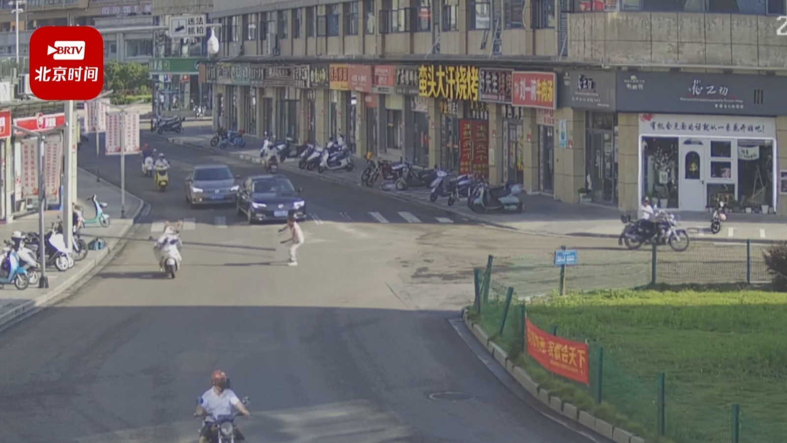 两人合抬钢管过马路 女子骑车被“拦头”