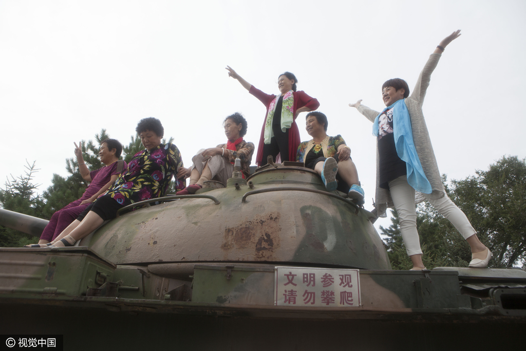 2016年8月10日，黑龙江省齐齐哈尔市和平广场内摆放了几尊大炮和坦克、飞机，供市民和游客观赏，可很多市民不顾危险和工作人员的劝阻，执意爬上高大的大炮上拍照留念。