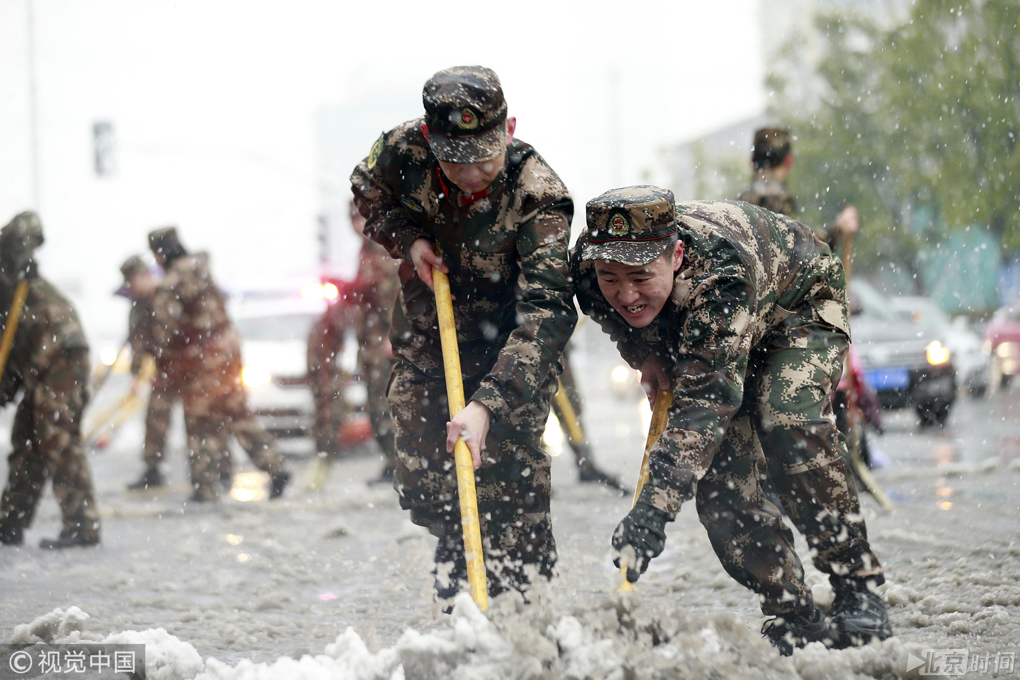 2018年1月4日，南京，江苏边防总队机关勤务保障大队官兵在大街上清理积雪。 当日，全国各地普降大雪，江苏发布暴雪黄色预警，驻地边防总队机关勤务保障大队组织80多名官兵走上街头，铲除积雪，确保了群众顺利出行。图/视觉中国