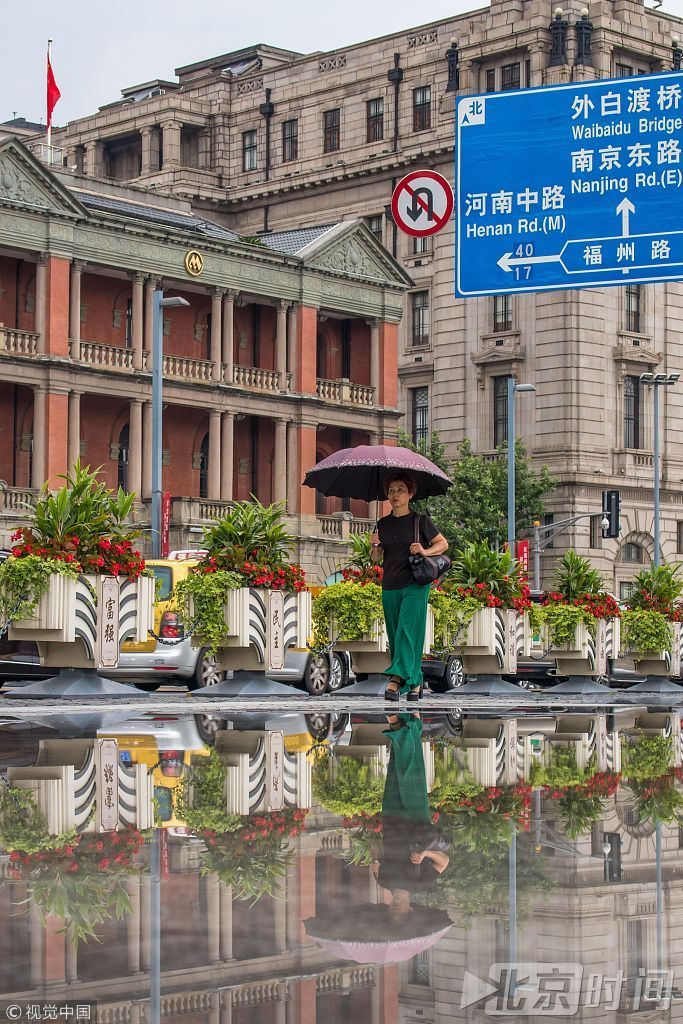 下午3时许，天空中雨势暂歇，中山东一路沿线外滩百年建筑群在积水上形成大片倒影，与天空中灰色云层相互掩映，好似一幅幅淡雅的水彩画，景色分外清丽。