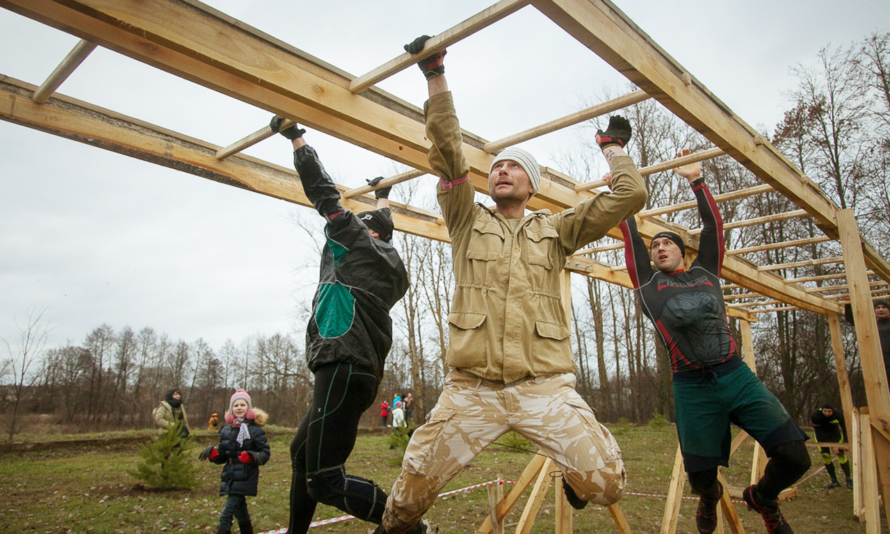 在这项赛事中，一条6英里的赛道中包含了20个紧张而疯狂的障碍。图为选手爬双杠。
