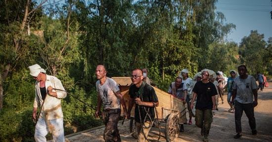 7月23日，井陉县南峪镇台头村，村民拉着车子走向村外，车上载着在洪水中遇难亲人的遗体。中国青年报·中青在线记者 赵迪/摄