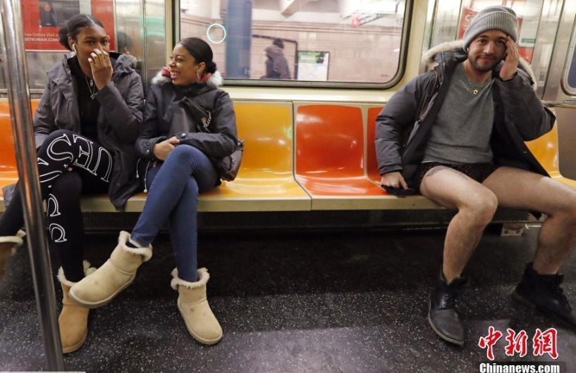 纽约地铁里，参加“无裤日”的一名男子与其他乘客坐在一起，略显清凉。