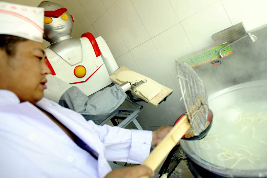 2011年4月26日，辽宁沈阳，一家面馆里的主厨“机器人”正在削面。该“刀削面机器人”是老板花2万元人民币买来，其工作量可达普通削面工3倍之多，工作10小时仅耗费1度电量。