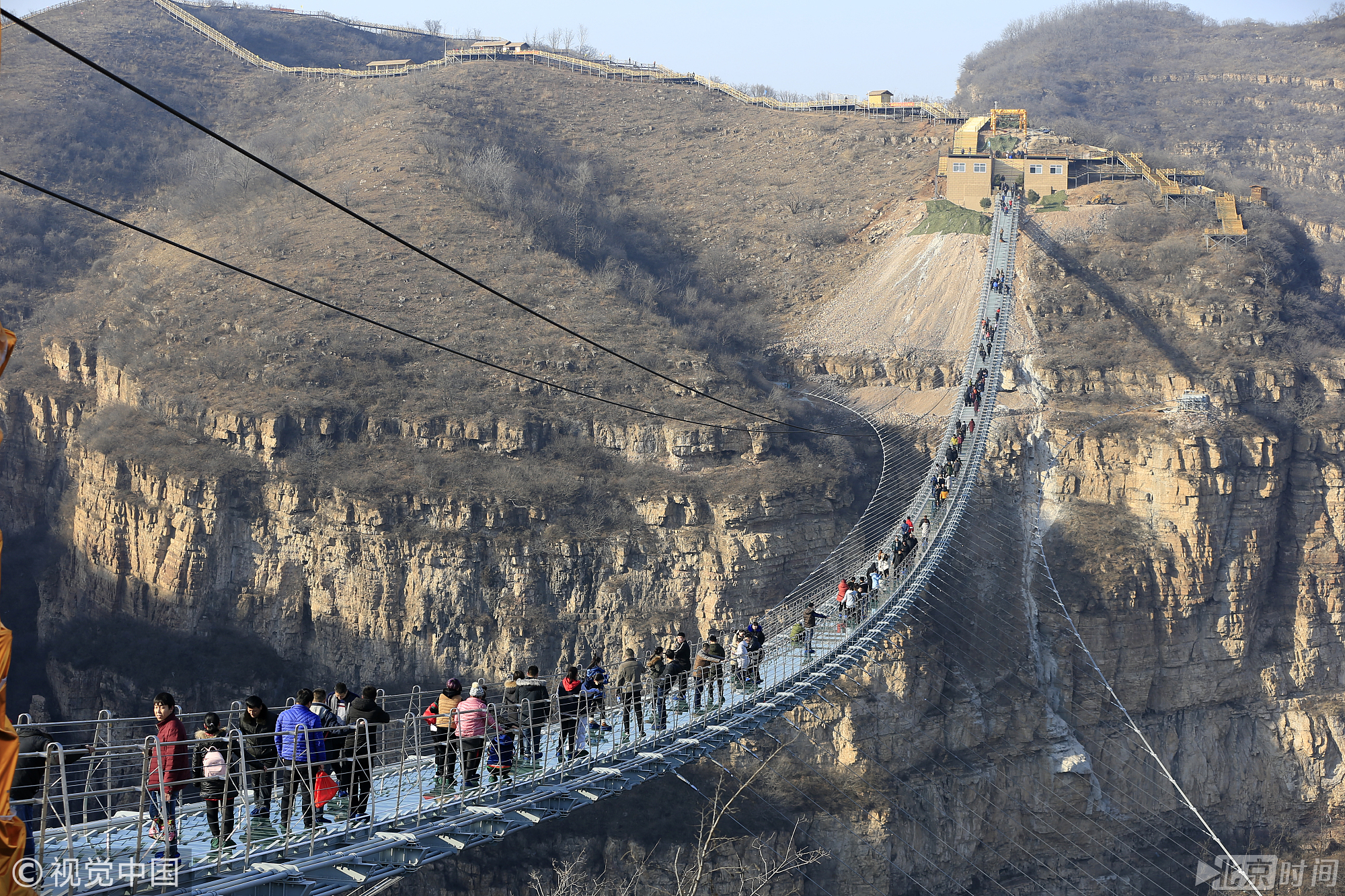 图为2017年12月26日，游客在红崖谷景区玻璃桥上行走体验。