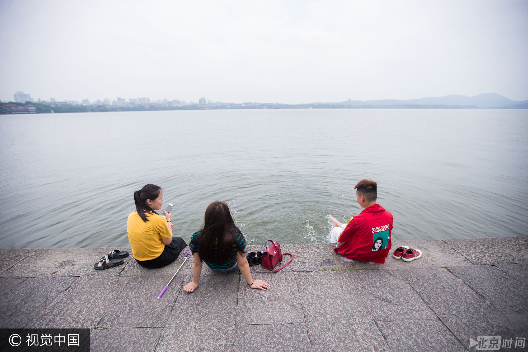 每年夏天，都会出现游客在西湖里洗脚、泡脚和戏水的场景，也引发了网友们的争议。有人认为这样的画面大煞风景，属于不文明行为，也有的网友认为这是亲近自然的表现，没必要太责备。