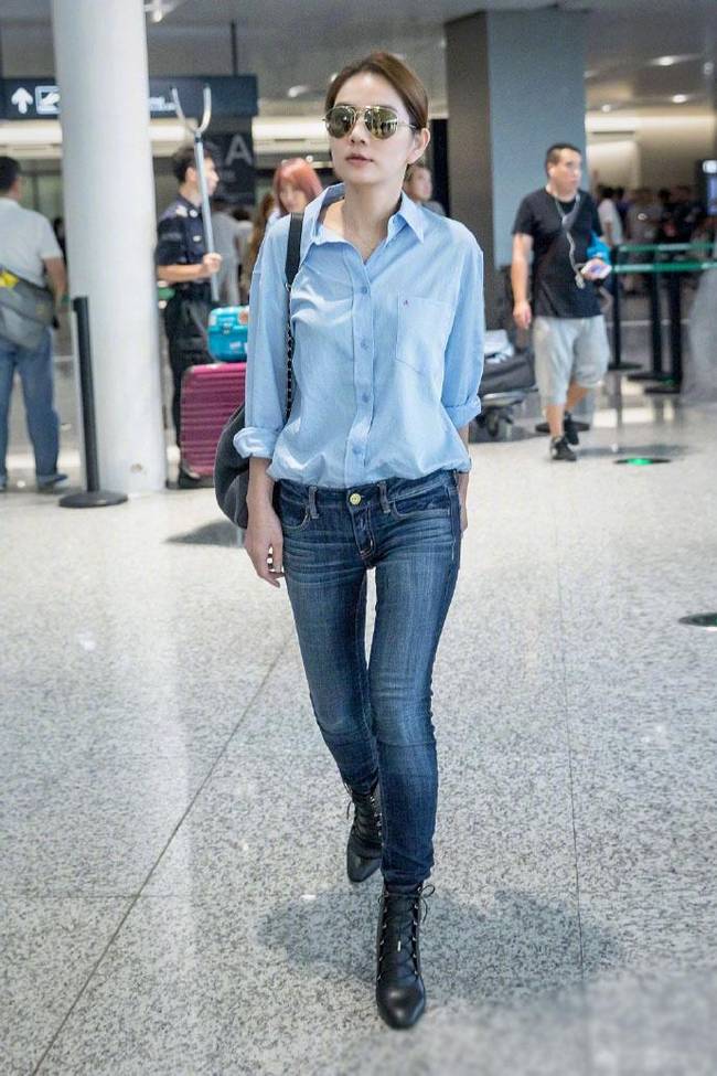 ella前往上海录制节目,墨镜遮面,上穿蓝色衬衫,下身穿着紧身牛仔裤