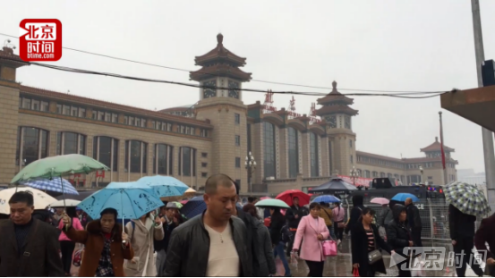 北京站旅客冒雨听报告 齐盼未来生活越来越好 北京站旅客冒雨听报告 齐盼未来生活越来越好
