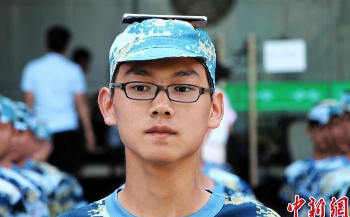 日前，在武汉工商学院2017级新生军训现场，该校17级物流学院物流工程专业方阵的新生头顶手机，每个队列排头和末尾的学生脚缠细线，绷直成一条悬空的直线，所有学生在教官的口令下统一做着动作。这种“别出心裁”的训练方式吸引了该校众师生的关注，而让人更意想不到的是这种“奇招”是学生们主动提出来的。 （来源：中新网）