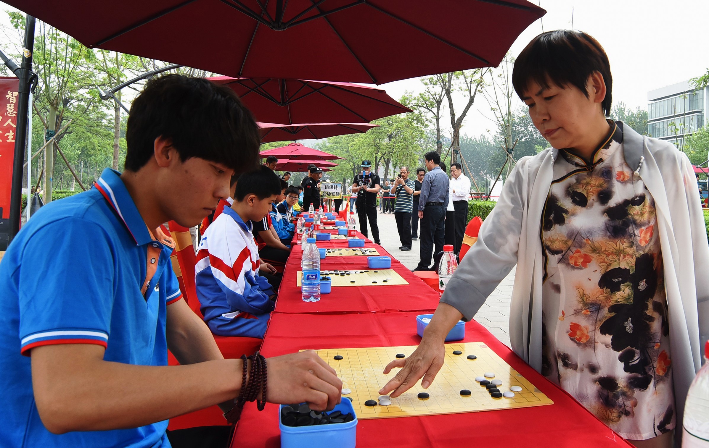 5月8日,中国围棋队领队华学明与小棋手对弈.新华社记者王晓 摄