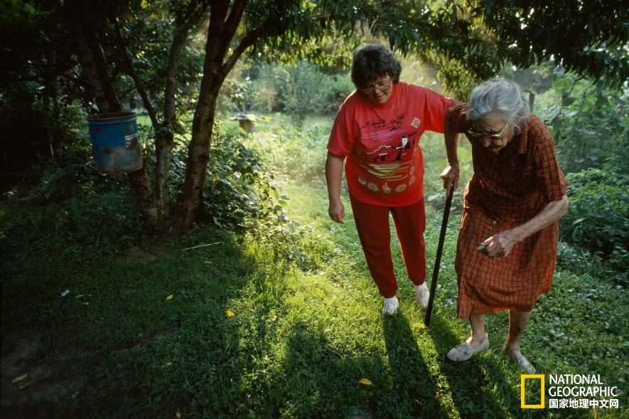 肯塔基州莱彻县（Letcher County），一位妇女搀扶着她的婆婆在自家花园里散步。该照片曾刊登于1993年的《国家地理》杂志。