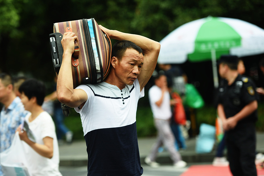 又到一年开学季 家长肩扛背挑送孩子进大学