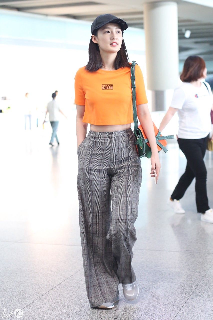 李沁现身北京机场,身穿橘黄色短袖配阔腿裤,大