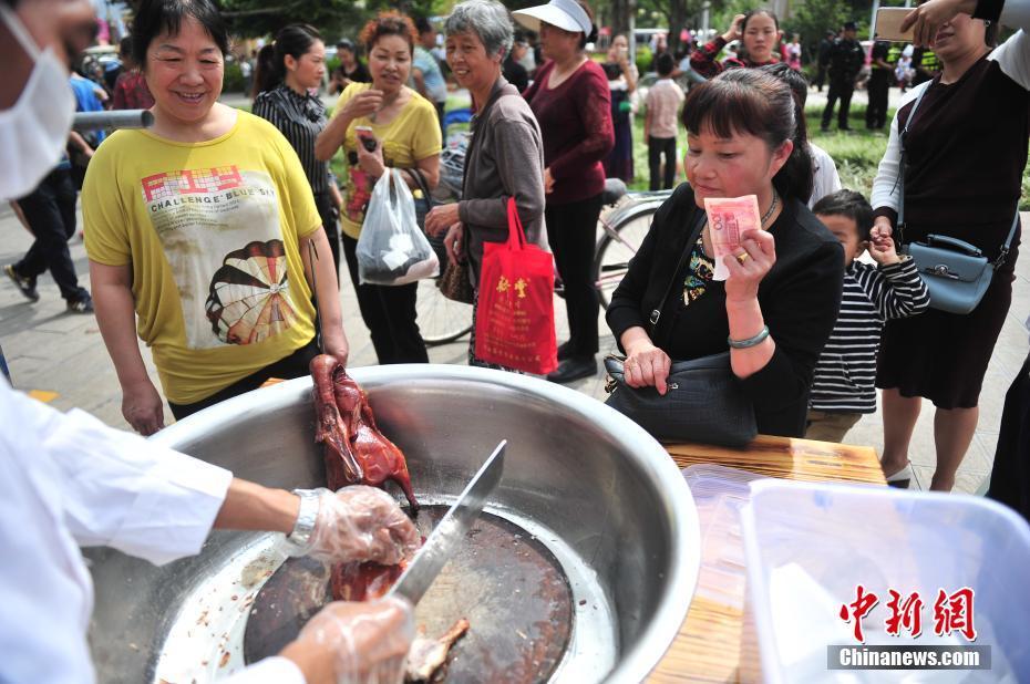 食客现场购买新鲜出炉的烤鸭。