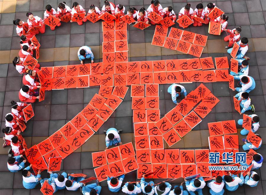 山东省淄博市沂源县荆山路小学书法社团的学生用书写的"龙"字摆图案