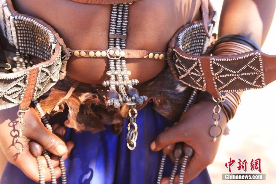 生活在纳米比亚的辛巴族又称“红泥族”，是非洲最后保持原始生态的部落之一。作为该部落最大特色，辛巴族女子终生不洗澡，且常年袒露上身，尤其喜欢把一种红色矿物粉末混合着奶油等涂抹在身上和头上。图为“红泥族”人的服饰。中新社记者 王曦 摄