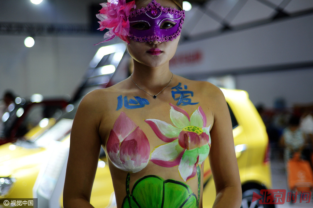 参展商邀请模特戴上面具，现场进行人体彩绘。