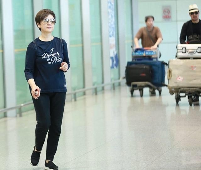 张国立邓婕双双现身机场:邓婕大步流星甩推箱的张国立老远