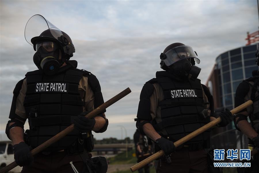 5月31日，在美国明尼苏达州明尼阿波利斯市，手握警棍的警察在街头警戒。