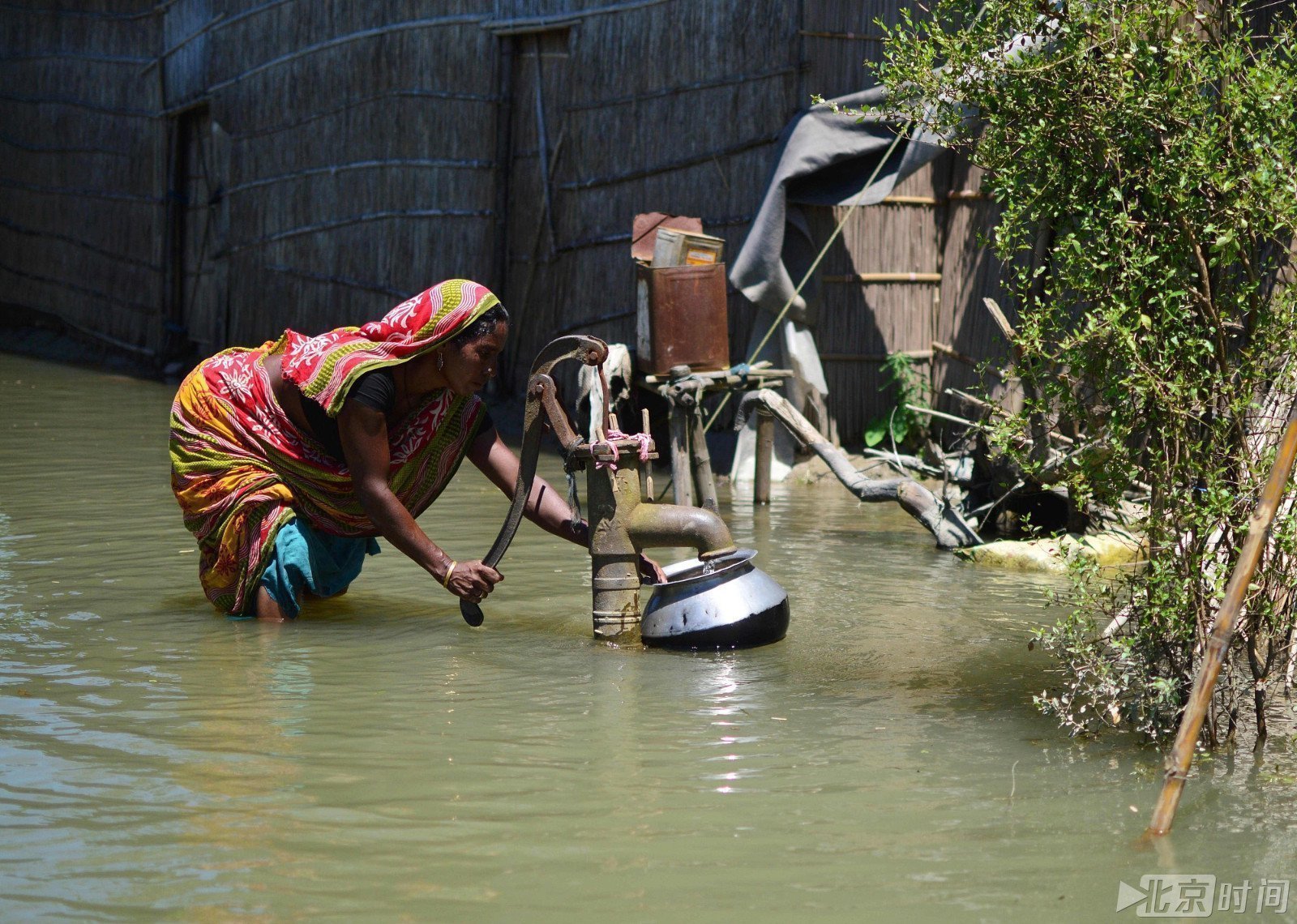 当地时间2017年7月14日,印度阿萨姆邦,一名妇女用抽水泵收集饮用水