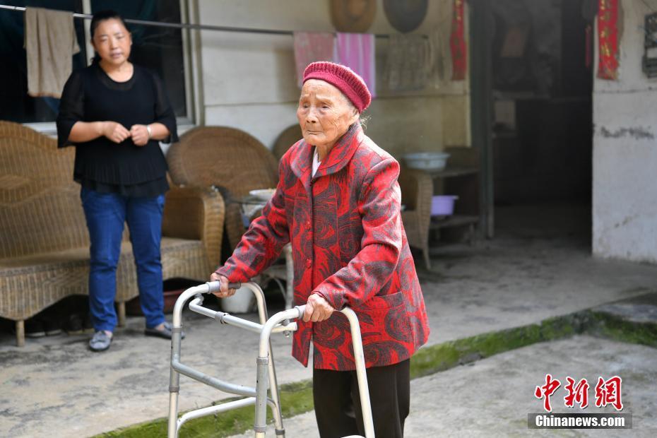 老人在2015年不小心摔跤后动了手术，如今靠着小椅子行走。